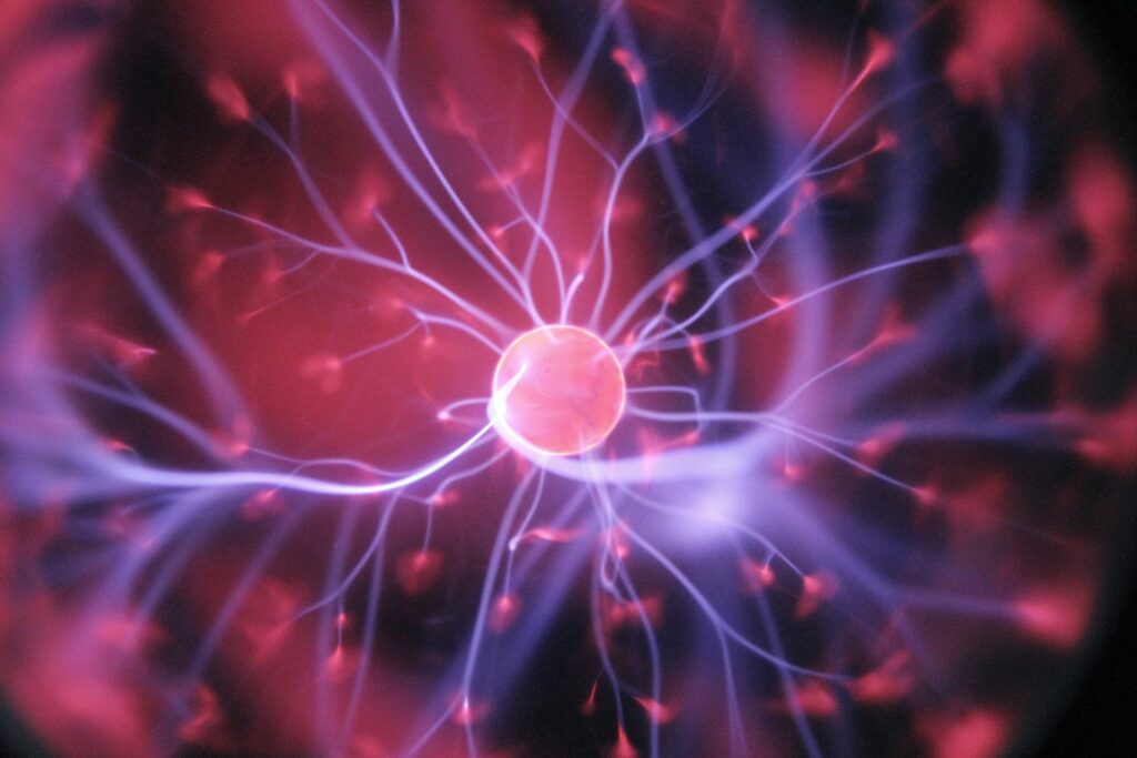 Plasma ball with orange-pink center and purple electrical plasma filaments
