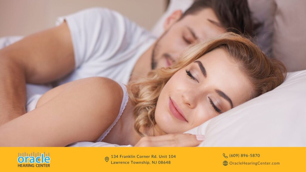 Young couple peacefully sleeping together in bed, both smiling and relaxed.