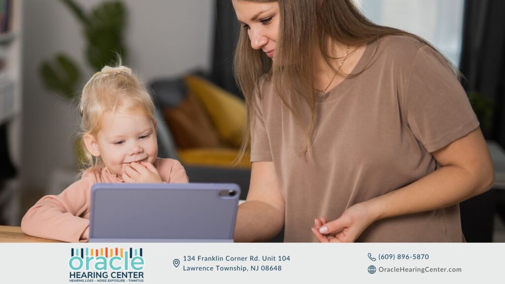 Mother and child using a tablet, representing cochlear implants and hearing aids for children